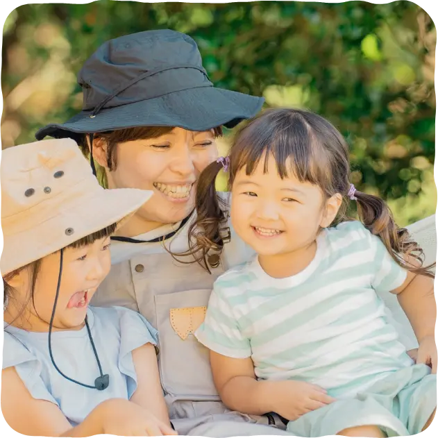 画像:お母さんと子どもたちが笑顔で寄り添っている様